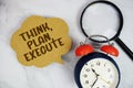 Think, Plan, Execute text with magnifying glass and alarm clock on marble background Royalty Free Stock Photo