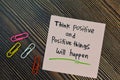 Think positive and positive things will happen write on sticky notes isolated on Wooden Table. Motivation concept