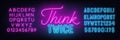 Think Twice neon lettering on brick wall background.