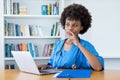 Thinking afro american nurse or medical student at computer Royalty Free Stock Photo