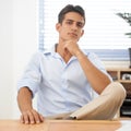 Thinking ahead in business. A handsome young businessman sitting behind his desk with his chin on his hand. Royalty Free Stock Photo
