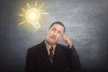 Thinking asian businessman got idea with bright light bulb over Royalty Free Stock Photo