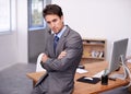 Thinking back on his career. A handsome young businessman sitting on his desk with his arms crossed. Royalty Free Stock Photo
