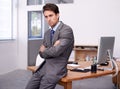 Thinking back on the past financial quarter. A handsome young businessman sitting on his desk with his arms crossed. Royalty Free Stock Photo