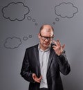 Thinking bald business man in eyeglasses discussing and have an idea on grey background. with empty clouds above the head. Closeup