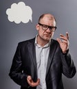 Thinking bald business man in eyeglasses and suit discussing and have an idea on grey background with empty cloud above the head.