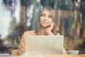 Thinking. Beautiful business woman with computer daydreaming, thinking about future plans Royalty Free Stock Photo