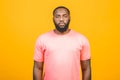 Thinking black Afro American man with serious expression looking, posing isolated against yellow background Royalty Free Stock Photo