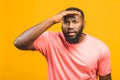 Thinking black Afro American man with serious expression looking, posing isolated against yellow background Royalty Free Stock Photo