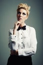 Thinking, bow tie or person with fashion, ideas or vintage clothes on grey background in studio. Classy aesthetic, edgy