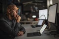 Thinking businessman using laptop and computer while working in late evening at the office Royalty Free Stock Photo