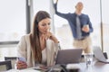 Confident business woman looking thoughtfully while using laptop at the office Royalty Free Stock Photo