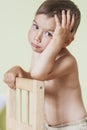 Thinking Caucasan Little Boy Sitting On Chair. Royalty Free Stock Photo