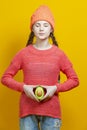 Female Fertile Concepts. Thinking Caucasian Girl In Coral Knitted Clothing Posing With Split Avocado Fruit In Front of Belly as a