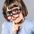 Thinking cheeky little kid trying many eyeglasses hesitating for choice
