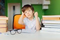 Thinking child bored, frustrated and fed up doing his homework Royalty Free Stock Photo