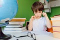 Thinking child bored, frustrated and fed up doing his homework Royalty Free Stock Photo