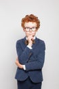 Thinking child boy with ginger hair wearing glasses and suit on white background