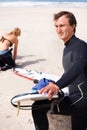 Thinking, cleaning and man with surfboard on beach for sports, training or getting ready to workout. Summer, vision and