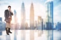 Thinking concept with pensive businessman on glossy floor on city skyscrapers background with copyspace. Double exposure Royalty Free Stock Photo