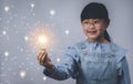 Thinking and creative concept, Asian girl holding the light bulb  in graph Screen Icon of media screen,Technology Process System B Royalty Free Stock Photo