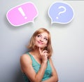 Thinking cute young woman with question and exclamation signs in