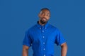 Monochrome portrait of young african-american man on blue studio background