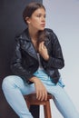 Thinking fashion model adjusting her leather jacket and looking away Royalty Free Stock Photo