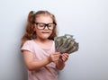 Thinking fun small kid girl in glasses counting money in the han Royalty Free Stock Photo