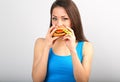 Thinking funny hungry excited woman eating burger and looking on blue background. Closeup