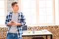 Thoughtful teenager holding his phone and thinking