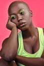 Thinking about greener pastures. a beautiful young woman wearing makeup while posing against a pink background.