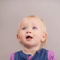 Thinking, happy baby and cute in studio with expression and playful with curiosity in mock up. Toddler, girl and healthy Royalty Free Stock Photo