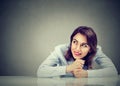 Thinking happy business woman sitting at desk looking to the side