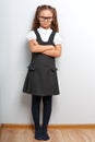 Thinking happy smiling pupil girl in fashion eyeglasses with folded arms in school uniform Royalty Free Stock Photo