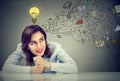 Thinking happy young business woman sitting at desk planning