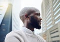 Thinking about his future success. Low angle shot of a handsome young businessman looking thoughtful while standing on Royalty Free Stock Photo