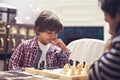 Thinking about his next move. a father and son playing a game of chess at home. Royalty Free Stock Photo