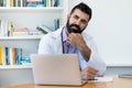 Thinking latin american mature doctor with hipster beard