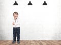 Thinking little boy in concrete room Royalty Free Stock Photo