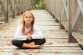Thinking little girl on bridge