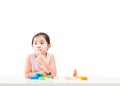 Thinking little girl with wooden building blocks on table Royalty Free Stock Photo
