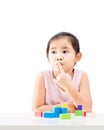 Thinking little girl with wooden building blocks on table Royalty Free Stock Photo