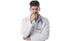 Thinking male doctor studio portrait while standing at isolated white background Royalty Free Stock Photo