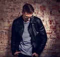 Thinking male model posing in leather jacket and trendy eyeglass Royalty Free Stock Photo