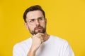 Thinking man isolated on yellow background. Closeup portrait of a casual young pensive man looking up at copyspace Royalty Free Stock Photo