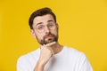 Thinking man isolated on yellow background. Closeup portrait of a casual young pensive man looking up at copyspace Royalty Free Stock Photo