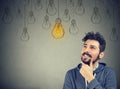 Thinking man smiling looking up at light idea bulb above head Royalty Free Stock Photo