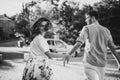 Thinking about new place to go. Beautiful young smiling couple hold hands each other and hurry to thier car Royalty Free Stock Photo