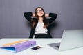 Thinking office worker day dreaming looking up smiling happy. Young business woman in suit sitting at office desk with laptop. Royalty Free Stock Photo